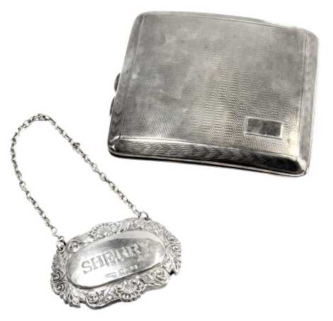 A George V silver cigarette case, of concave form, with engine engraved decoration and vacant cartouche, Birmingham 1928, 3.45oz, and a George V silver sherry label, 0.39oz. (2)