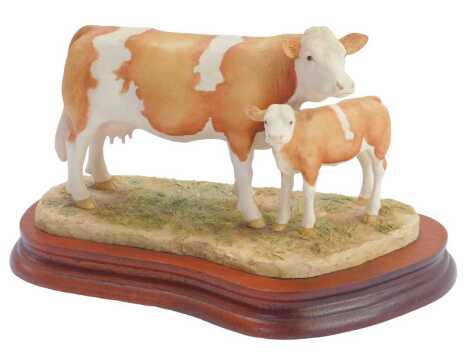 A Border Fine Arts figure group, of cow and calf, on a wooden base, 16cm high.