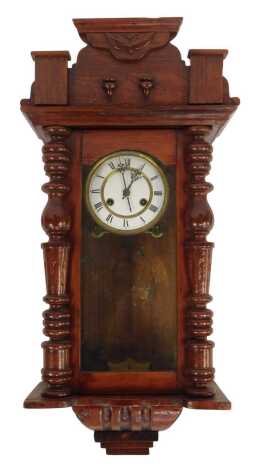 A 19thC mahogany Vienna wall clock, with turned columns supports and astragal glazed door, on a white enamel dial with Roman numerals and brass border, eight day movement, with coil strike, 52cm high, 31cm wide, 18cm deep.