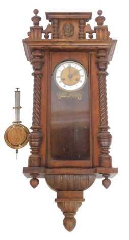 An early 20thC walnut cased Vienna wall clock, the brass dial with white enamel chapter ring bearing Roman numerals, eight day, 95cm high.