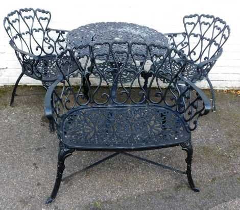 A cast metal garden set, comprising two-tier table, two chairs, and a bench, with heart motif decoration.