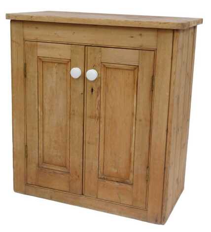 A Victorian pine cupboard, the top with a rounded edge above two panelled doors enclosing shelf, 97cm high, 90cm wide, 47.5cm deep.