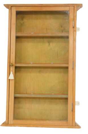 A pine display cabinet, the glazed door enclosing an arrangement of shelves, 119cm high, 71ccm wide, 11cm deep.