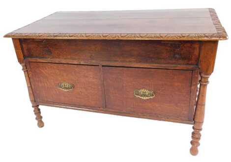 A late 19thC oak desk, the rectangular top with a rounded carved edge, later adapted to a chest with two deep drawers to base, on turned cylindrical legs, 73cm high, 119cm wide, 67cm deep.