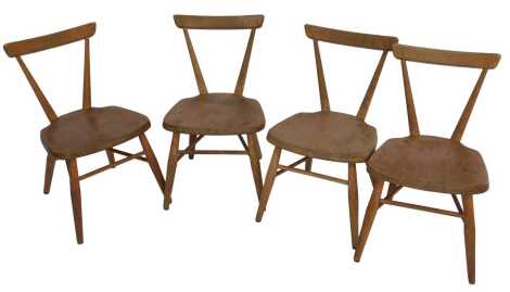 Four Ercol beech and elm child's chairs, each with a V shaped back, solid seat, on cylindrical legs united by stretchers, stamped REG. DESIGN No. 884892.