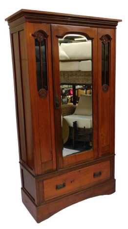 A Victorian walnut single wardrobe, the out swept pediment over a door inset with bevelled glass, flanked by two floral carved glass backed panels, above a frieze drawer, raised on a plinth base, 192cm high, 105cm wide, 47cm deep.