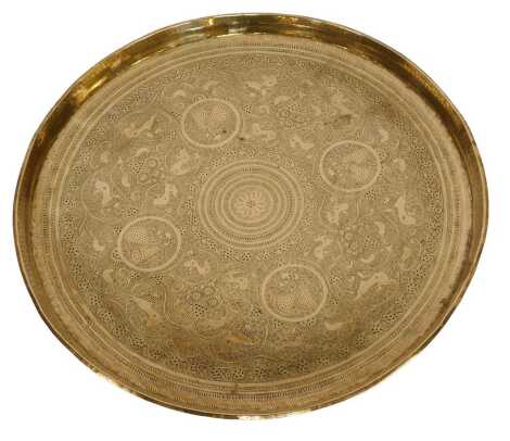 An Indian brass tray, with chased decoration depicting animals, figures, etc., 66cm diameter.