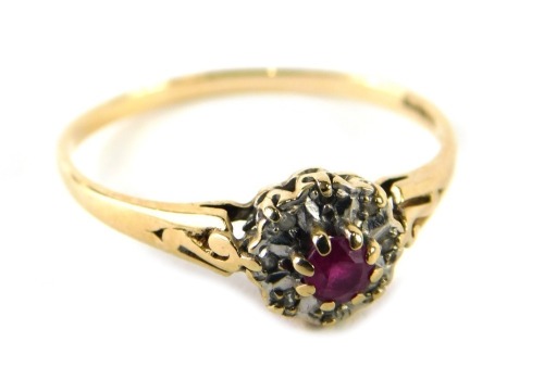 A 9ct gold ruby and diamond dress ring, the central ruby in four claw setting, surrounded by eight illusion set tiny diamonds, ring size P½, 1.6g all in.