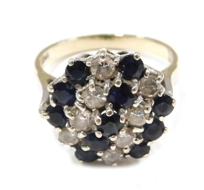 An 18ct gold sapphire and diamond dress ring, the raised panel set with three rows of round brilliant cut sapphires and two rows and diamonds, ring size O, 5.2g all in.