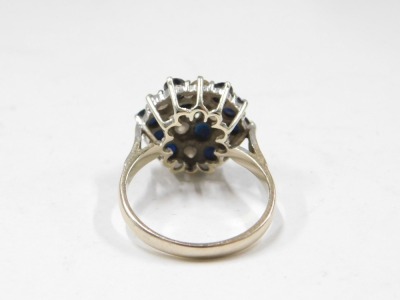 An 18ct gold sapphire and diamond dress ring, the raised panel set with three rows of round brilliant cut sapphires and two rows and diamonds, ring size O, 5.2g all in. - 2