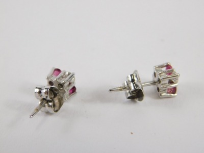 A pair of ruby and diamond stud earrings, each set with two round brilliant cut diamonds approx 0.05cts and two rubies, in white gold setting, unmarked, 2g all in. - 2