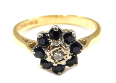 An 18ct gold sapphire and diamond cluster ring, set with central diamond, surrounded by eight sapphires, each claw set, ring size M, 3.2g all in.