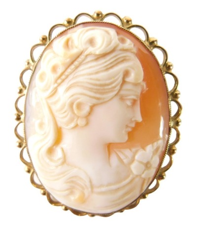 A 9ct gold framed shell cameo brooch, the oval cameo depicting figure looking dexter in a pierced border on single pin back, 4cm x 3cm, 10g all in.