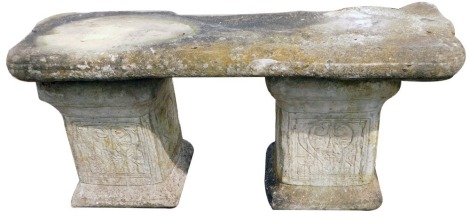 A reconstituted stone garden bench, the rectangular top on two rectangular tapered column supports, each with floral decoration, 45cm high, 94cm wide.