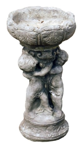 A reconstituted stone birdbath, the bowl top supported by three intertwined cherubs, on a circular base, 54cm high, 32cm wide.