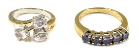 Two modern dress rings, comprising a TQVC crossover ring, white metal stamped 925, ring size J½, and a further silver dress ring set with amethyst, ring size P, 6.9g all in. (2)