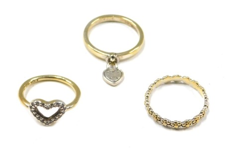 Three Pandora style dress rings, comprising one with love heart drop, one formed with daisies, and another with central love heart, each stamped 925 ALE, 7.1g all in. (3)