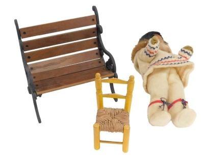 A miniature doll's two seater bench, with cast ends, 22cm high, 24cm wide, side chair and a plush doll. (3)