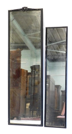 A rectangular ebonised wall mirror, with scroll crest, 198cm high, 60cm wide, and a smaller ebonised mirror, 168cm high, 37cm wide.