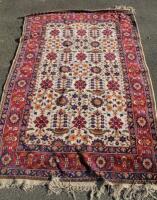 A Persian style cream and red ground carpet