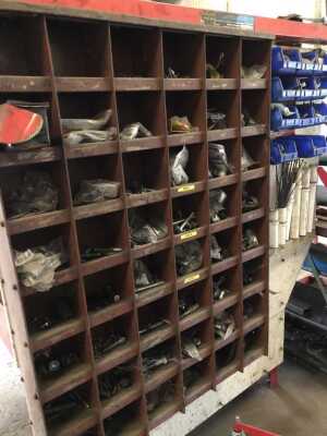 A red steel tray top work bench, with drawer, undershelf and vice, and backed with parts bins, 150cm wide, the tray 65cm deep plus 20cm of bay. - 2