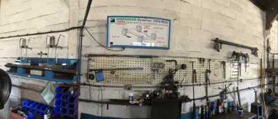 A Hofmann Dynaliner 2500/4500 laser four wheel alignment system, including illuminated sign, laser mounts, and a tool rack wall mounted with associated and other items. - 2