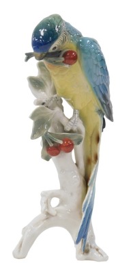 A Karl Ens porcelain figure of a parrot, modelled perched on a tree, with cherries, printed mark, 31.5cm high.