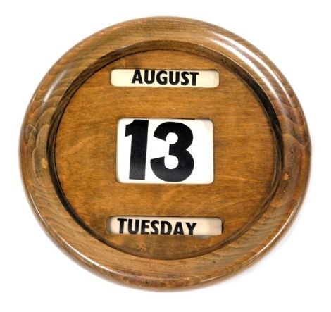 An early 20thC circular oak cased perpetual calendar, 31cm diameter.