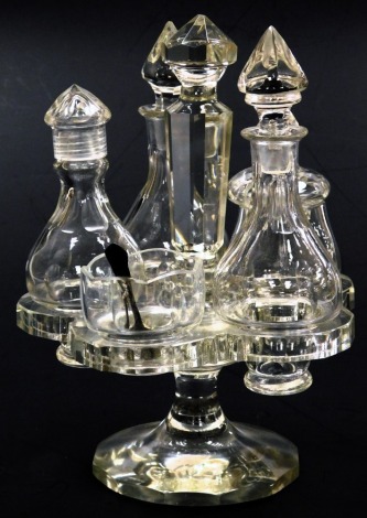 A Victorian glass five piece cruet set on stand, comprising three bottles and stoppers, mustard pot and cover and an open salt, with silver spoon, 22.5cm high.