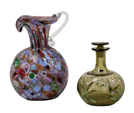 A Murano millefiori glass jug, with a clear glass scroll handle, together with an early 20thC continental green glass scent bottle and stopper, enamel decorated with insects and flowers, 11cm high. (2)(AF)