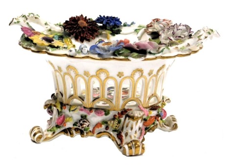 An early 19thC English porcelain basket, of twin handled and pierced circular form, painted and encrusted with flowers and seashells, raised on four scroll feet, 25.5cm wide. (AF)