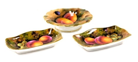 A Royal Worcester porcelain footed dish, circa 1937, painted by A Shuck, with peaches and grapes, 9.5cm diameter, together with a pair of serpentine pin dishes, circa 1937, painted with peaches and grapes, signed indistinctly, printed marks. (3)