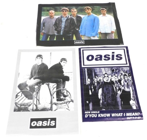 Three Oasis posters, comprising full colour band pose, an official poster issued by the Verkerke Netherlands, original line up 1996, 91cm x 61cm, black and white pose sat on stool, issued late 1990s, to be sold in record shops at the time, 84cm x 58cm, an