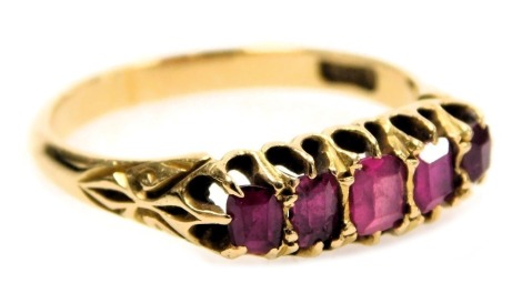 A ruby five stone ring, claw set, in yellow metal, stamped 18ct, size S, 4.6g.