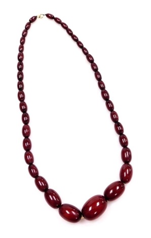 A string of graduated cherry amber beads, on a bolt ring clasp, largest bead 2.5cm, 43.2g.