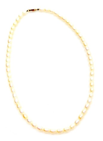 A string of uniform baroque pearls, on a yellow metal lobster claw clasp, stamped 9k.