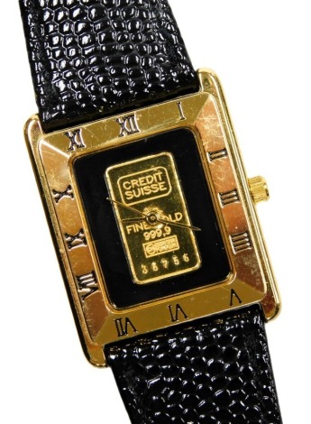 A Credit Suisse lady's gold plated wristwatch, containing a .999 gold ingot to the centre of the dial, number 36756, on a leather strap.