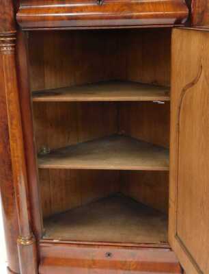 An early Victorian flame mahogany corner cupboard, with a shaped pediment over a serpentine door, flanked by turned columns, over a cushion drawer, panelled door enclosing two shelves, and further cushion drawer, flanked by turned columns, raised on a pli - 2