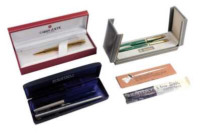 A Caran d'Ache ball point pen, in gold coloured engine turned decoration, together with an Elysee two pen set, in green, and two Sheaffer ball point pens.