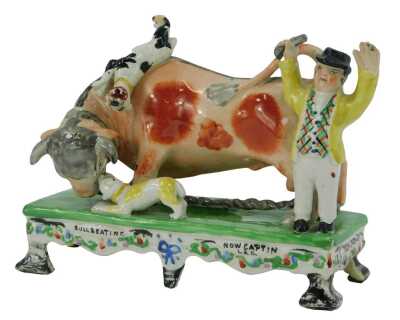 An early 19thC Staffordshire pottery figure group, titled Bull Beating Now Captain Lad, 14cm high. (AF)