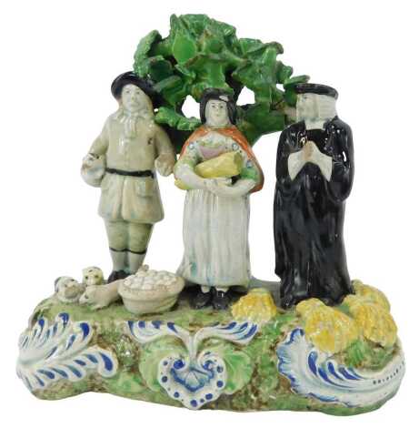 An early 19thC Staffordshire pottery figure group, modelled as The Tithe Pig Group, 17cm high. (AF)