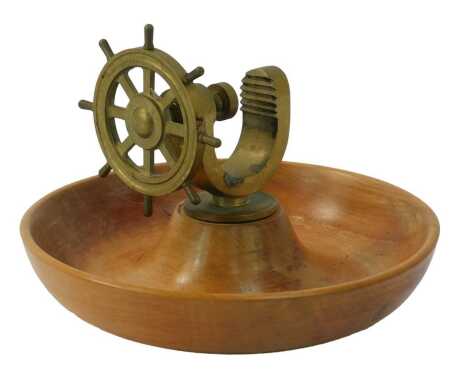 A 20thC teak ship's wheel nut bowl, the central raised brass nut cracker formed as a ship's wheel, 16cm high.