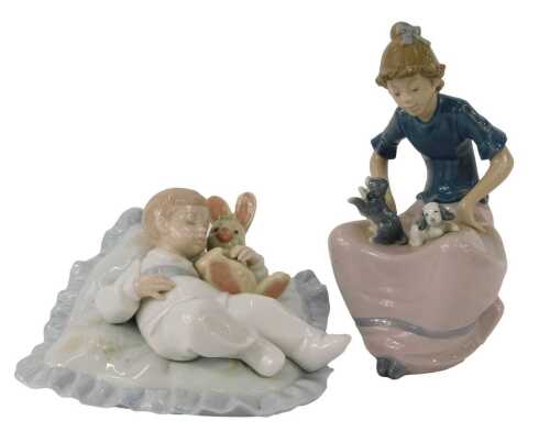 A Lladro porcelain figure, modelled as a child seated on cushion with rabbit, 14cm high, together with a Nao porcelain figure of a girl with puppies, 17cm high. (2)