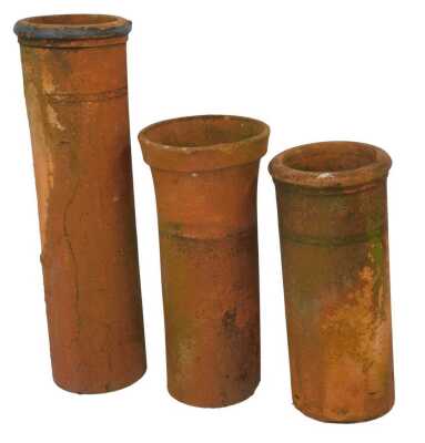 Three terracotta chimney pots, comprising one with fluted top, 75cm high, another straight example, 70cm high, and a straight and ribbed example, 104cm high. (3, AF)