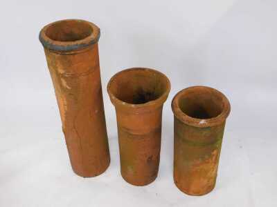 Three terracotta chimney pots, comprising one with fluted top, 75cm high, another straight example, 70cm high, and a straight and ribbed example, 104cm high. (3, AF) - 2