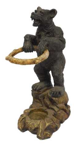 A Black Forest type carved wooden umbrella stand, modelled as a standing bear holding a branch ring, on a rocky base, 95cm high, 35cm wide, 45cm deep.