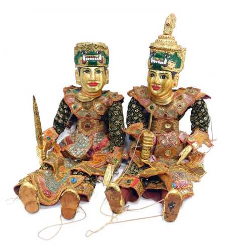 Two South East Asian wooden puppets, each with embroidered cloth, and gilt overpainted wooden heads and feet, on string supports. (2)