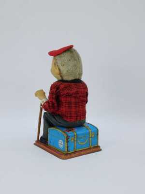 A 20thC tinplate figure of a gentleman seated with walking cane on Russian suitcase, by Roscoe, 30cm high. (AF) - 3