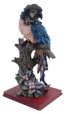 A 20thC resin sculpture of a parrot on a perch, with pink breast and blue feathers, on a rectangular hardwood base, 58cm high, 26cm x 24cm.