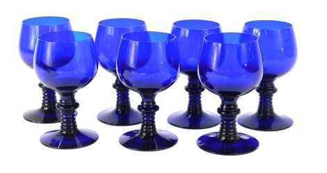 A set of seven Bristol Blue glass wine goblets, each with a ribbed stem, on a circular foot, 14cm high.